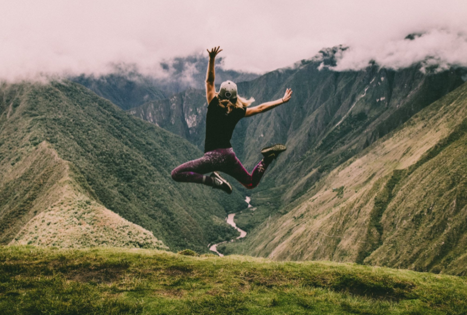 Woman jumping in the air near mountains