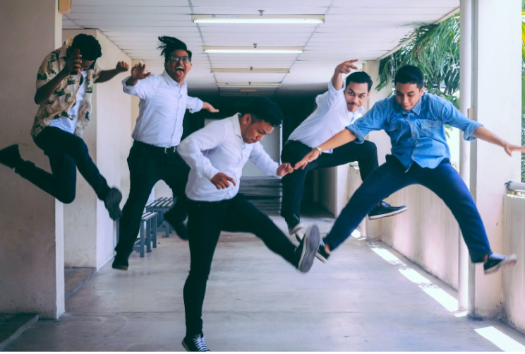 5 employees jumping in the air